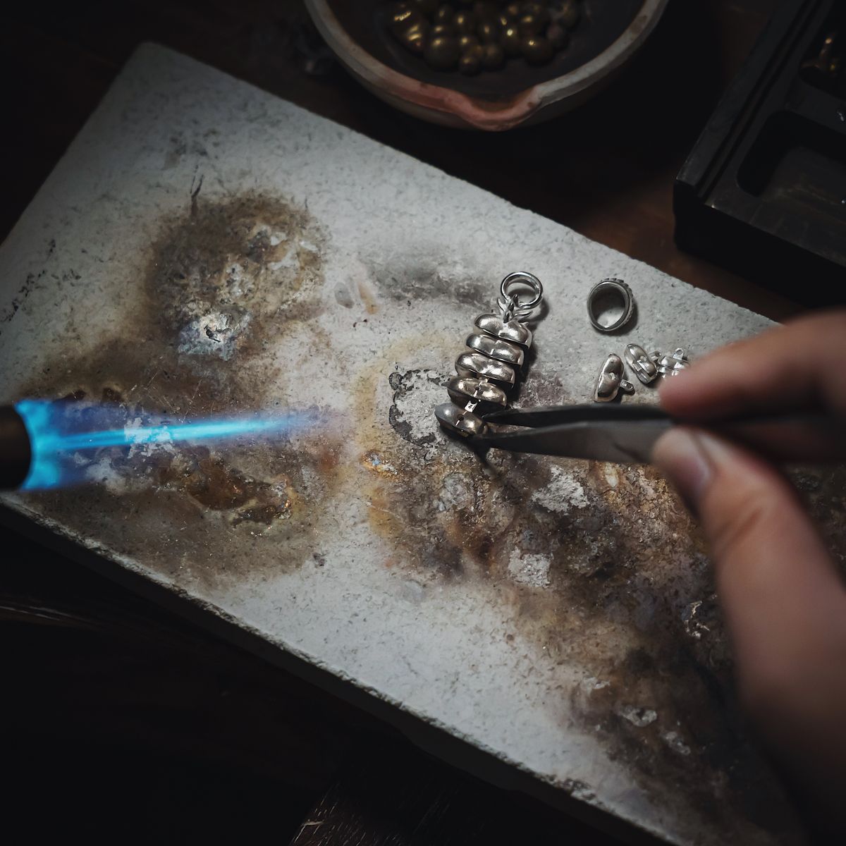 Artisan hand-finishing a silver piece at the bench