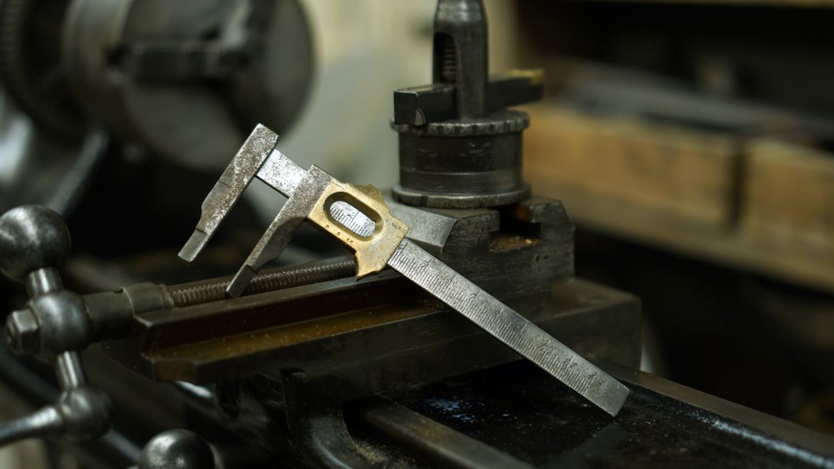 Caliper measuring a machined metal part during quality control